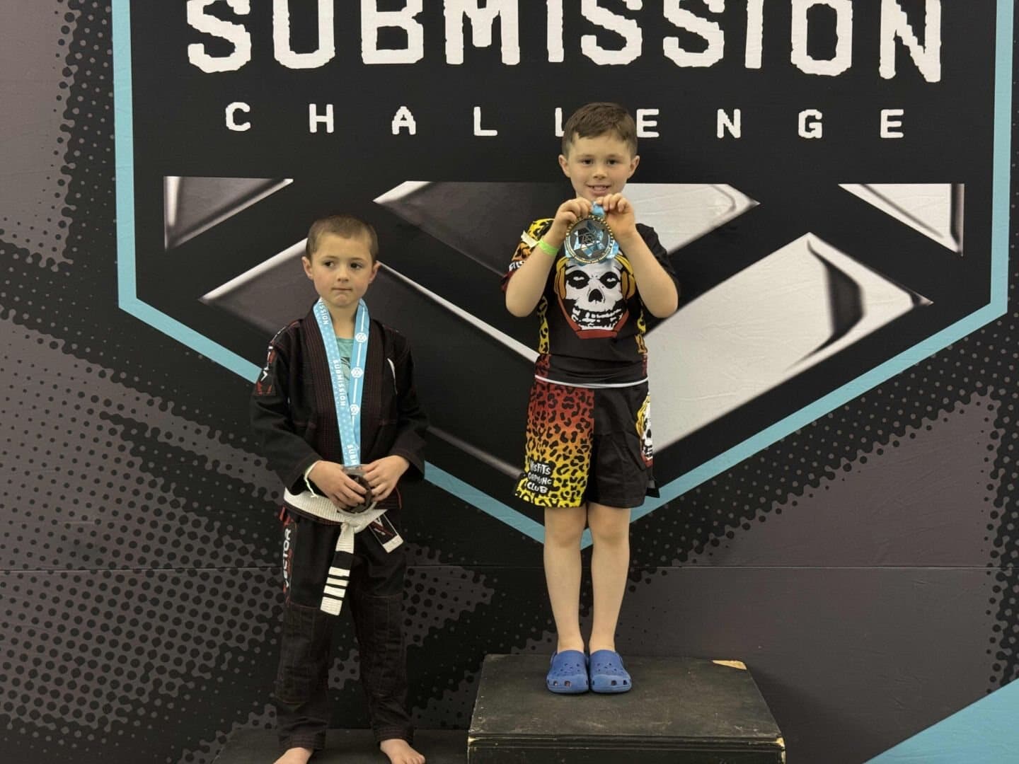 Two young Misfits grapplers on a Submission Challenge podium with medals