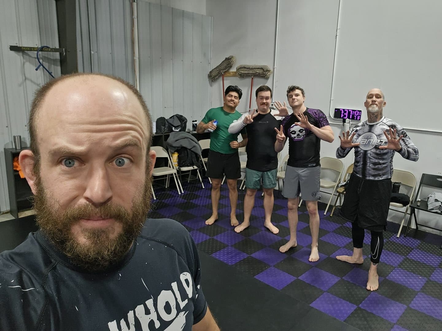 A candid team shot on the purple-tiled mat, 10th Planet rashguards
